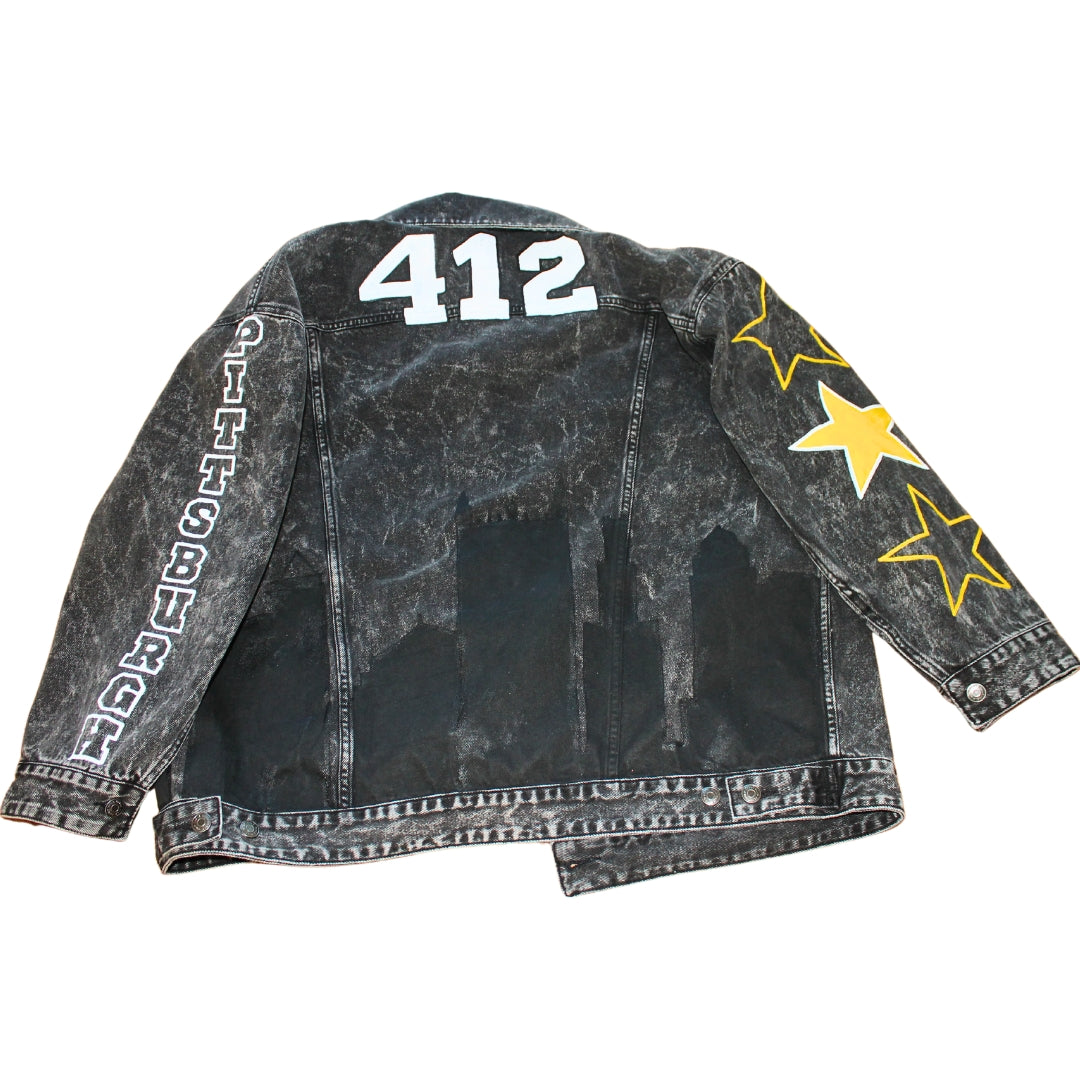 A black denim jacket featuring hand-painted city skyline, stars on sleeves, city name, and symbols for urban flair.