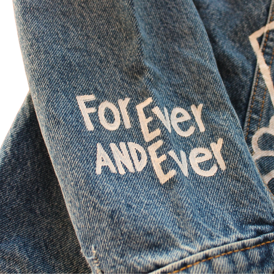 Hand-Painted Bridal Denim Jacket featuring delicate flowers, personalized with initials and love quote. Unique and chic fashion for a memorable wedding day. #BridalStyle #WeddingFashion